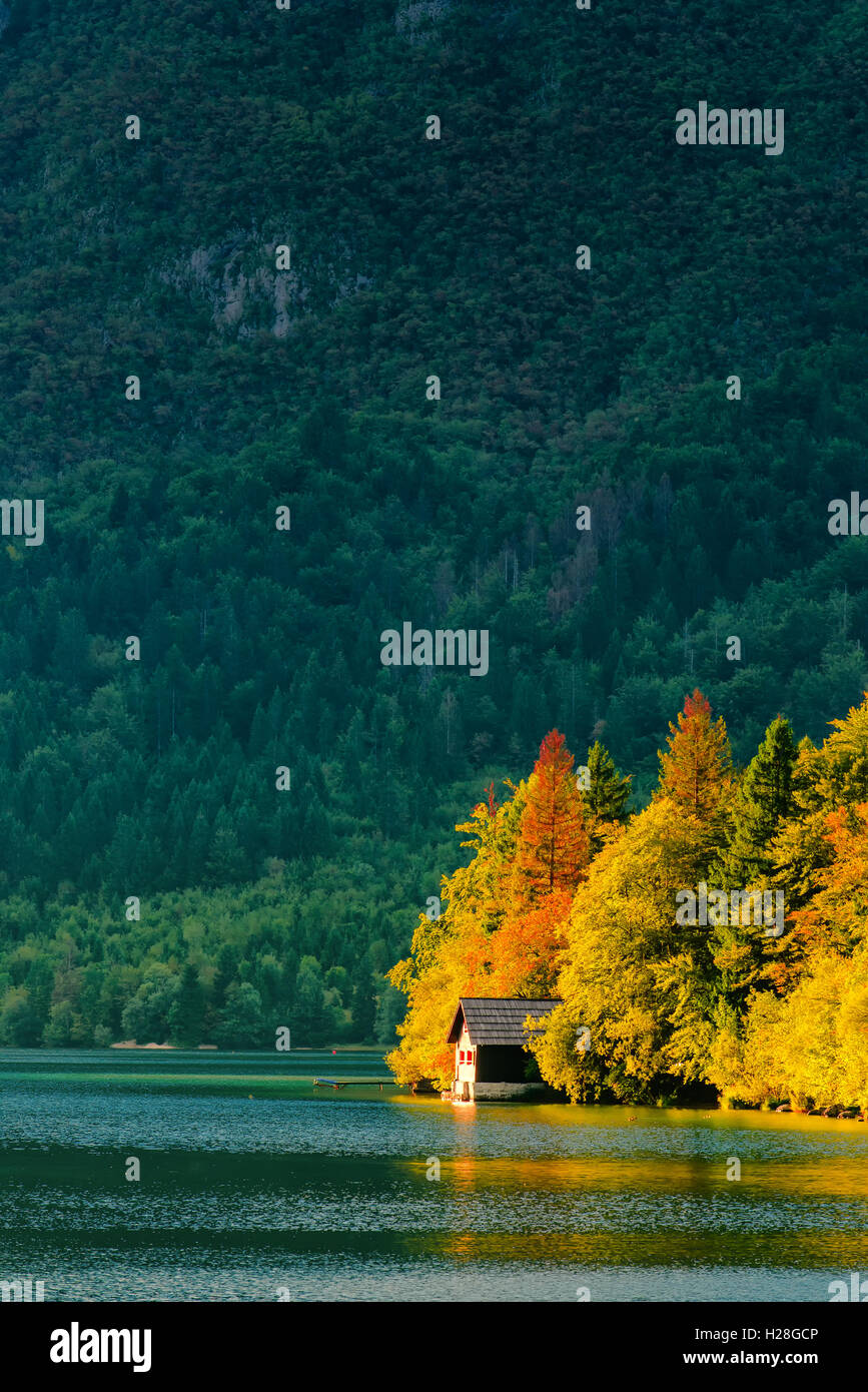 Belle petite maison maison au lac de Bohinj en slovène Triglav national park en automne coucher du soleil. Banque D'Images