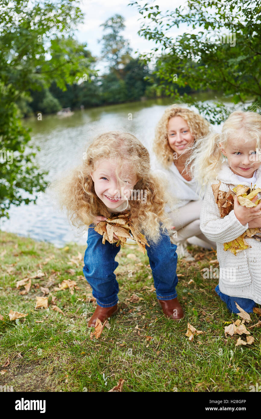 Les filles s'amusant lors de la collecte des feuilles à l'automne dans la nature Banque D'Images