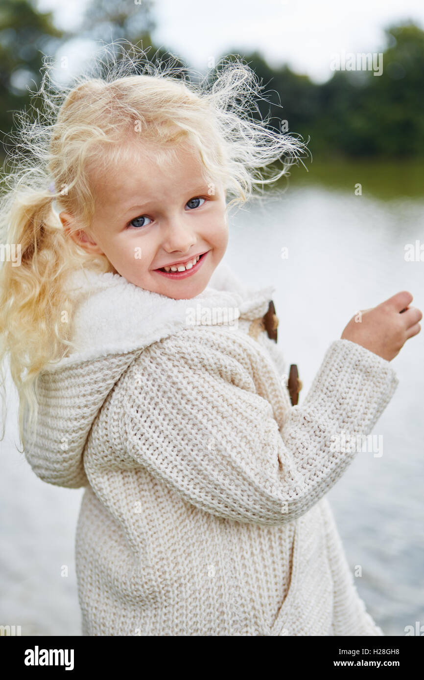 Petite fille aux boucles blondes dans la nature en automne Banque D'Images