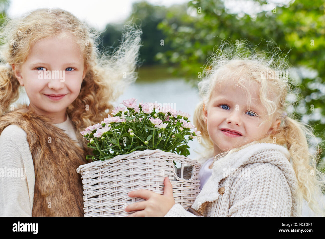 Aider les enfants avec des fleurs dans un jardin en automne Banque D'Images