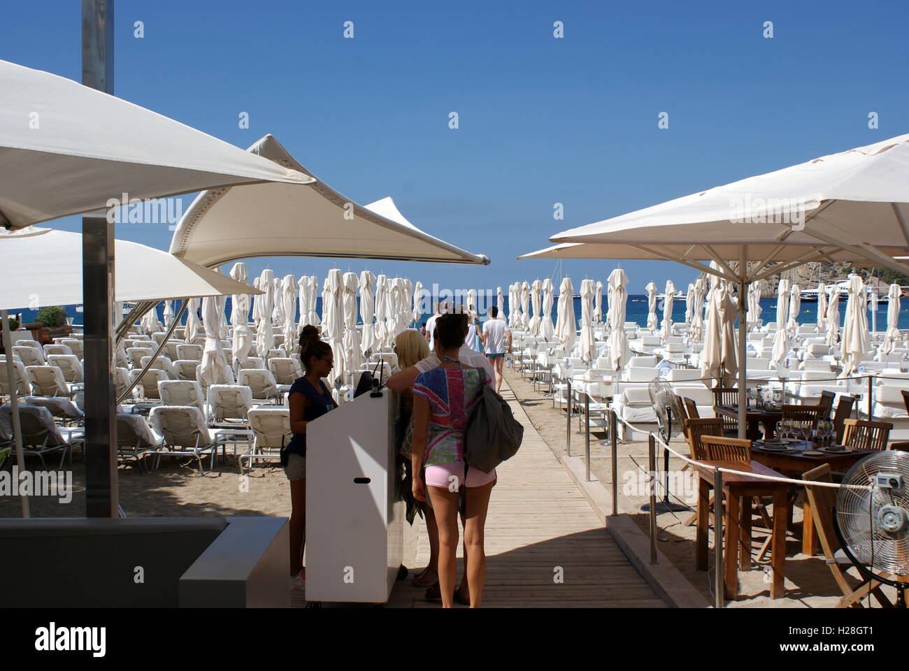 Les premiers clients de la journée au Blue Marlin club de plage, Cala Jondal, Ibiza Banque D'Images