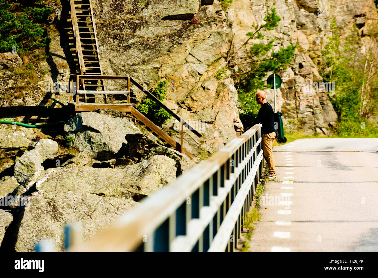Askeron, Suède - septembre 9, 2016 : Environmental film de mâles adultes appuyé contre une rambarde du pont donnant sur t Banque D'Images