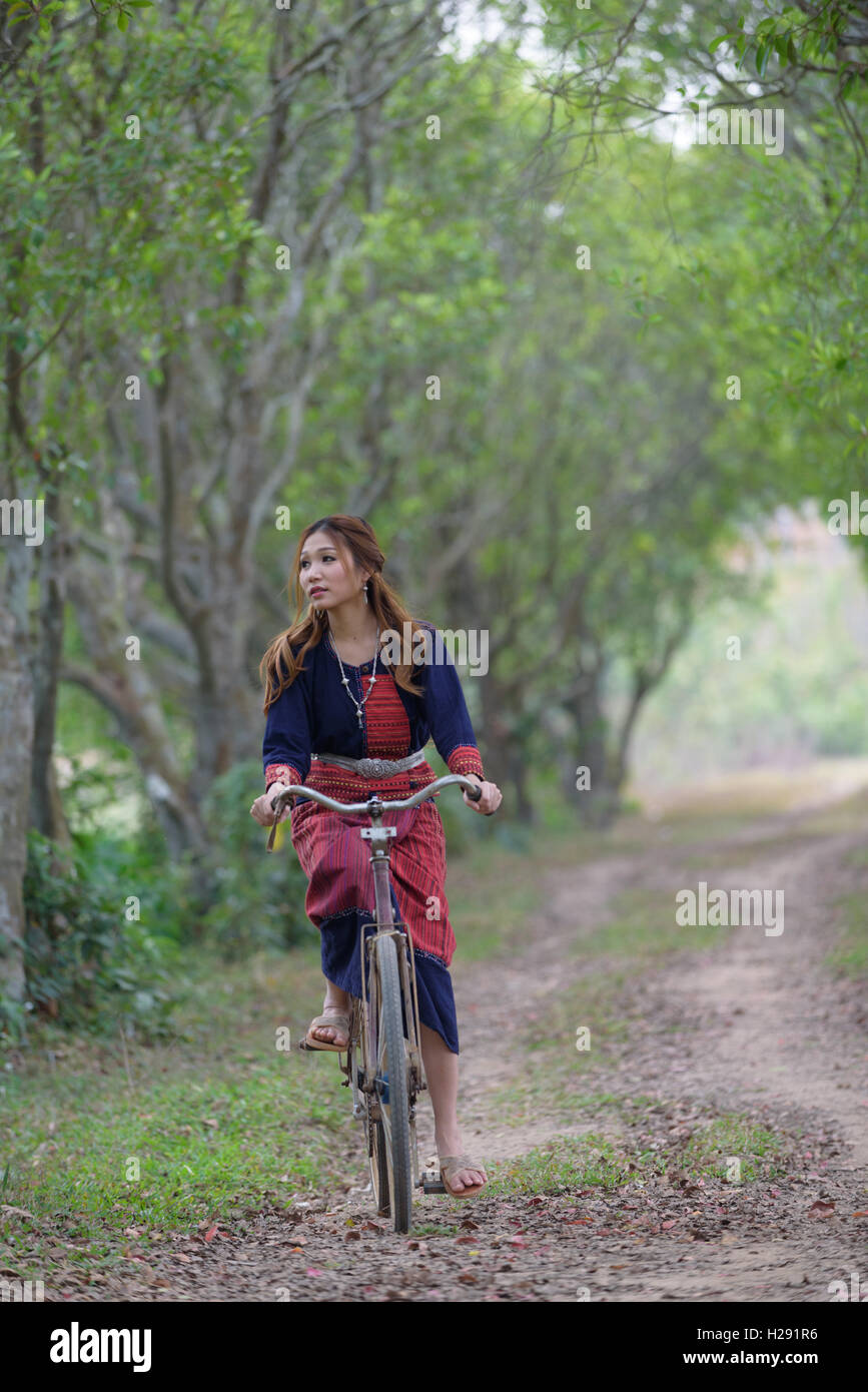 Les jeunes femmes asiatiques équitation un vieux vélo dans la zone.Thaïlande Banque D'Images