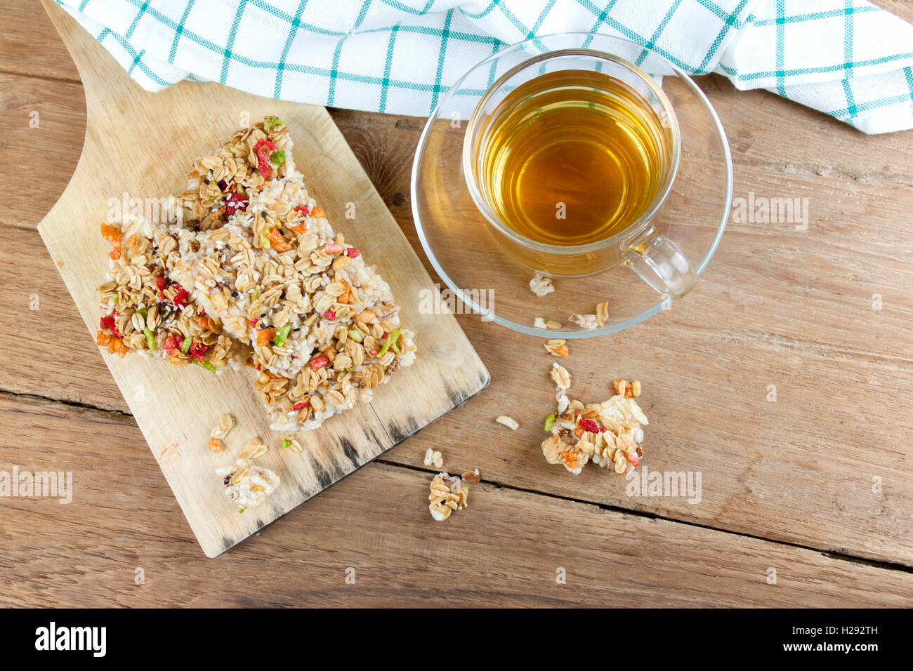 Barre granola céréales croustillantes ou des biscuits de riz avec un verre tasse de thé chaud sur la table de bois. Banque D'Images