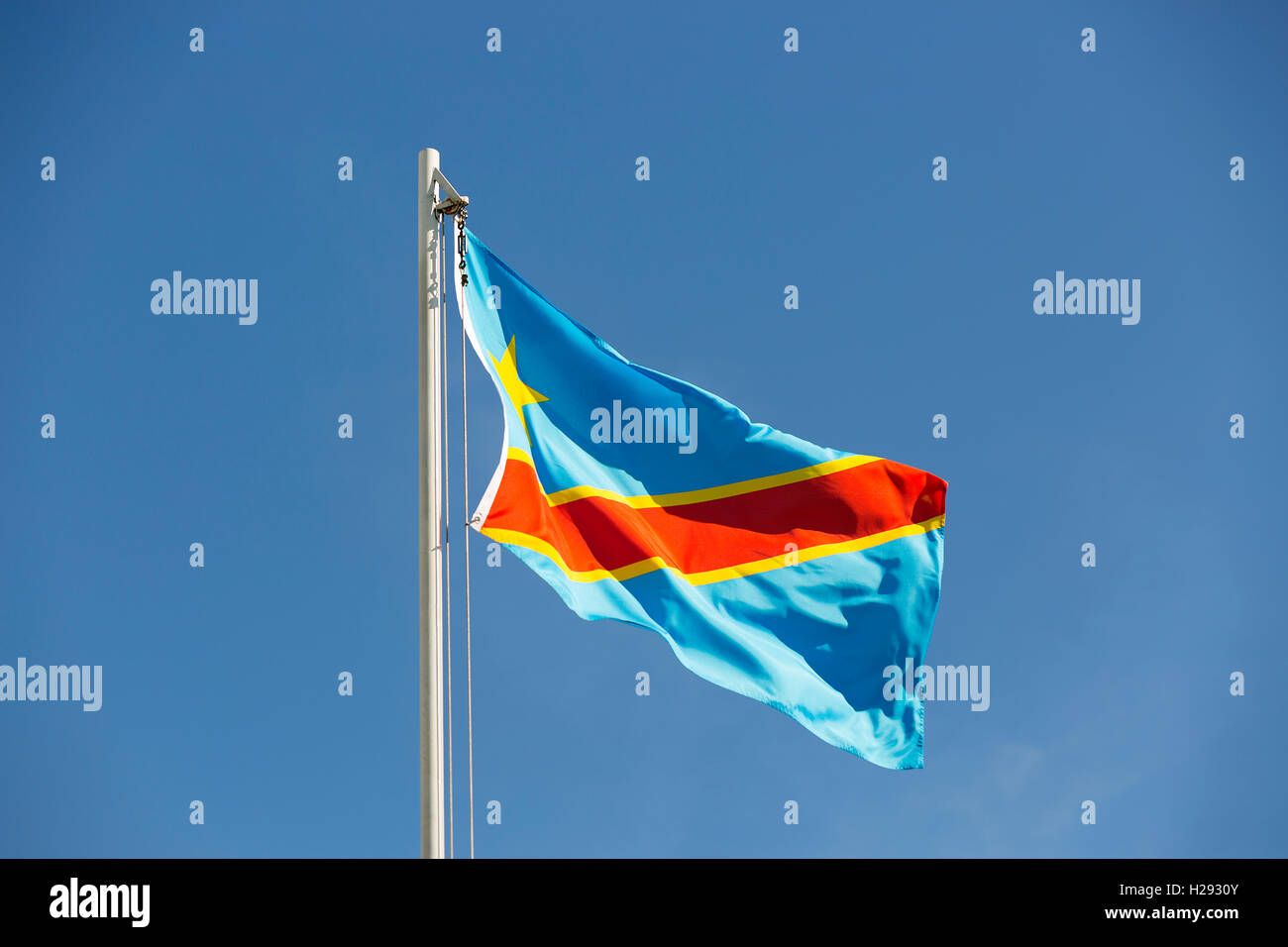 Drapeau national du Congo sur un poteau en face de ciel bleu Banque D'Images