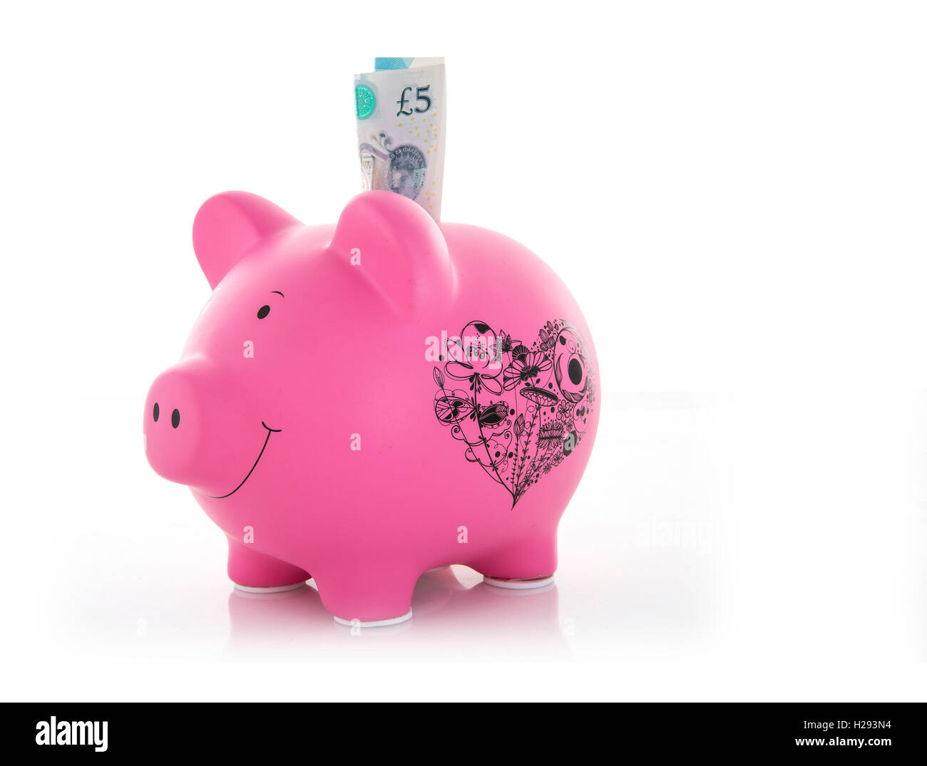 Pink Piggy Bank avec cinq nouveaux pound note sur un fond blanc Banque D'Images