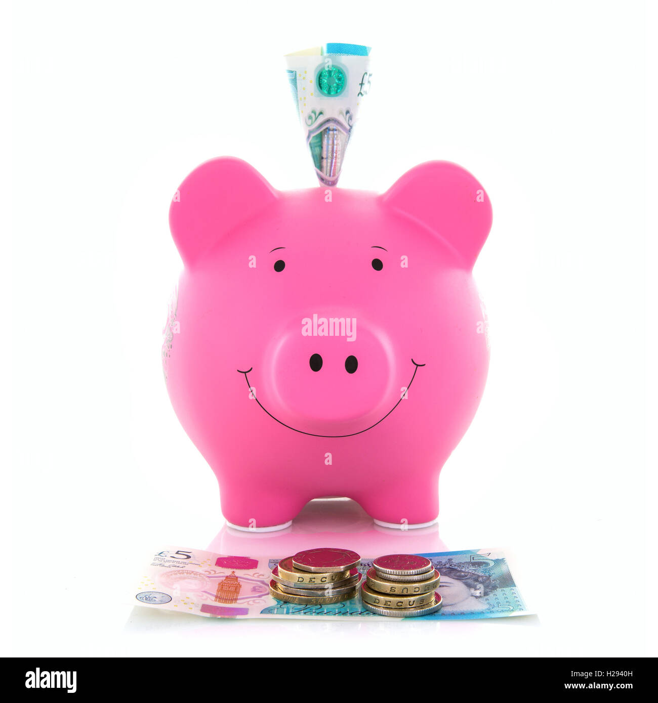 Pink Piggy Bank avec polymère nouveau livre cinq notes sur un fond blanc Banque D'Images