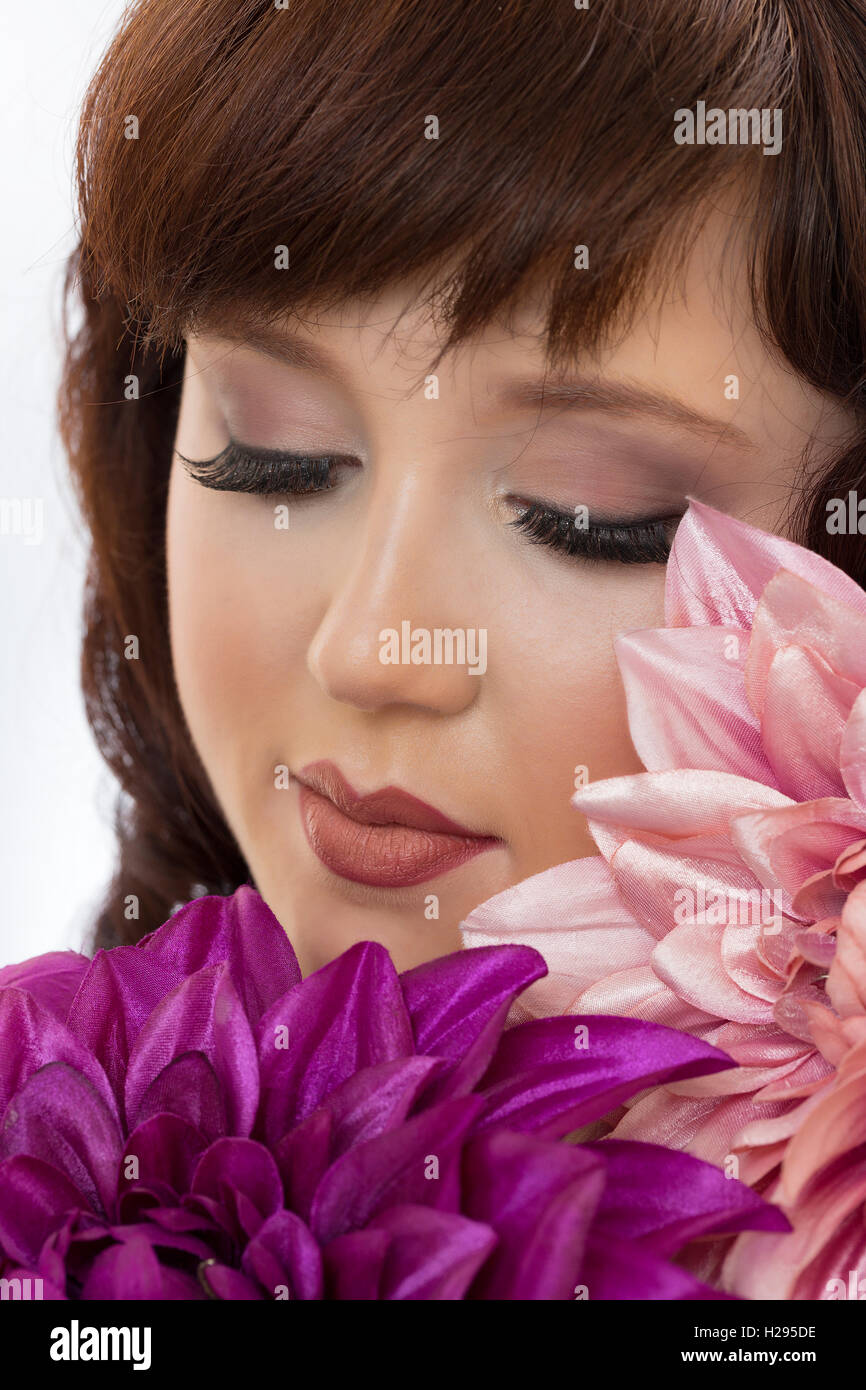 English rose femme brune Auburn close up portrait, les yeux clos avec d'énormes fleurs rose et violet Banque D'Images