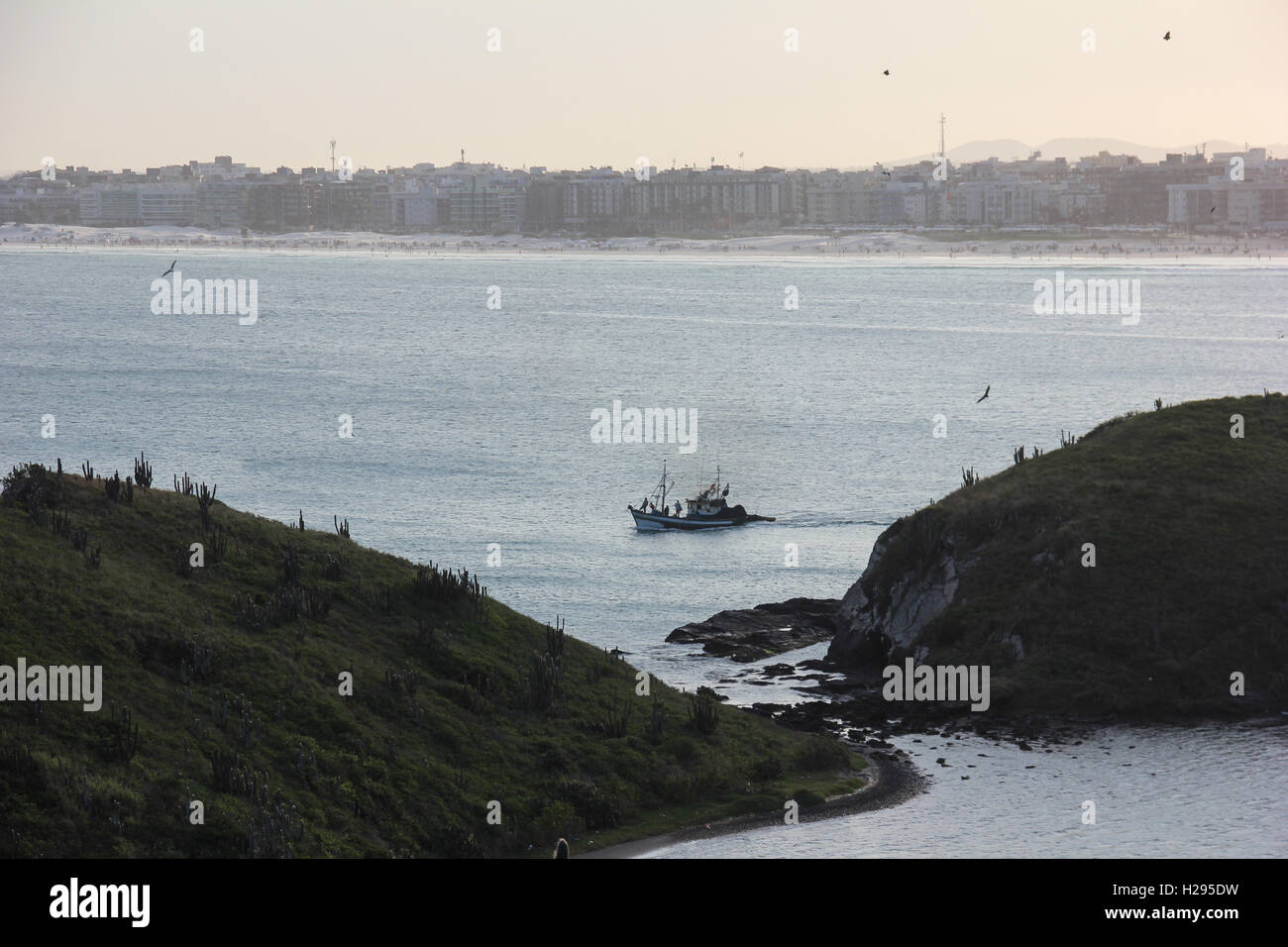 Bateau de pêche parmi les rochers dans la mer de Cabo Frio ville dans la région des lacs de l'État de Rio de Janeiro, Brésil. Banque D'Images