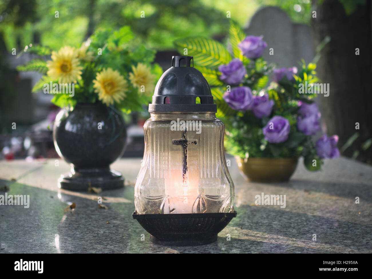 Bougie et des fleurs sur la tombe. Banque D'Images