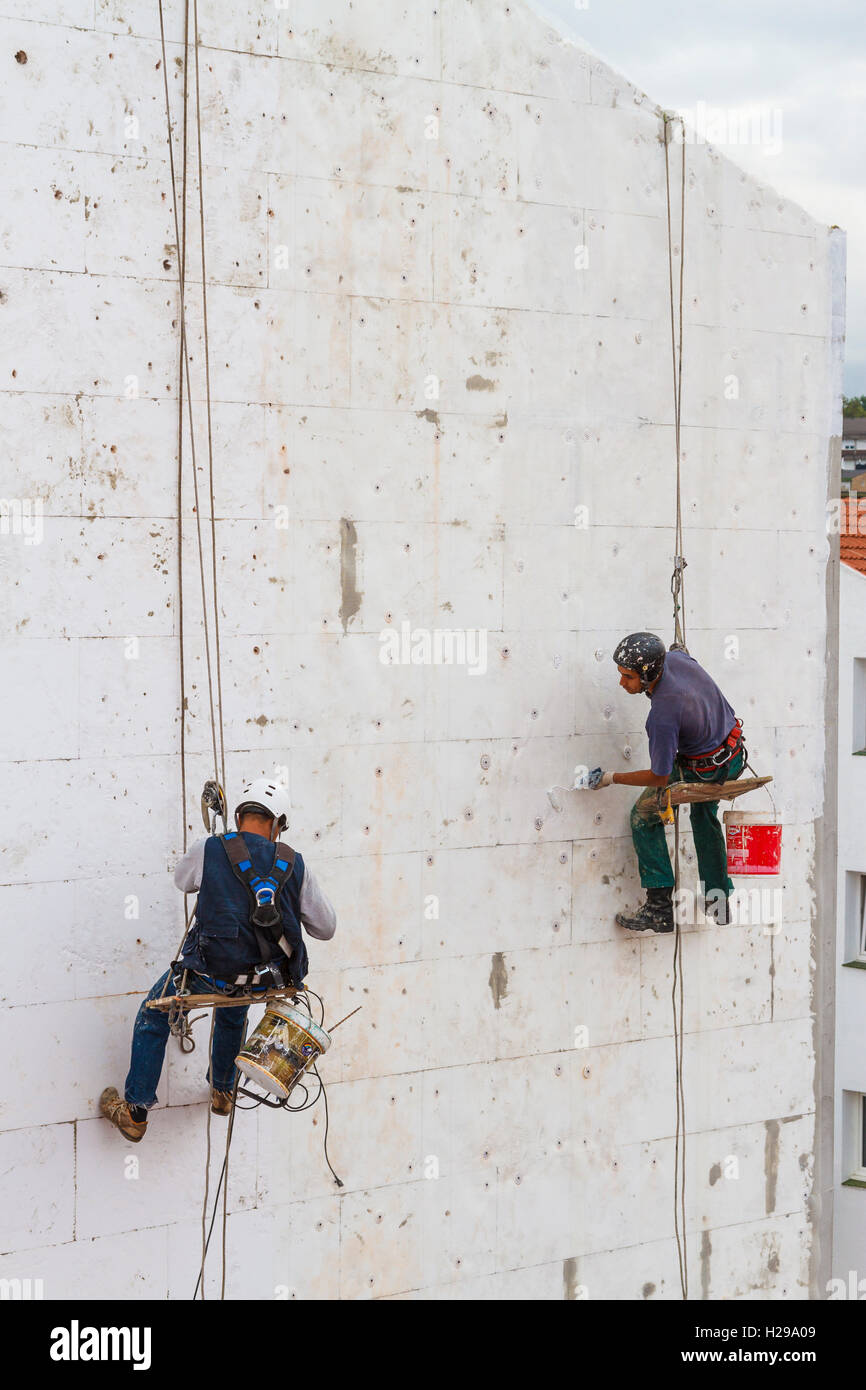Travailleurs qualifiés travaillant dans un mur de la maison. Banque D'Images