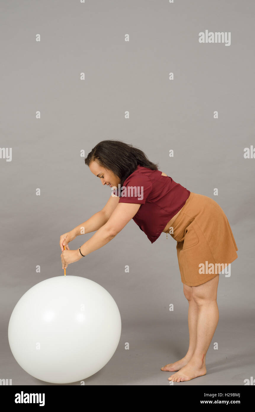 Femme adulte débordant un énorme ballon avec un crayon Photo Stock - Alamy