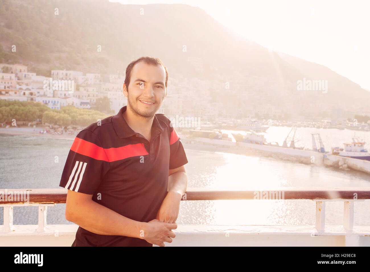 Jeune homme souriant et regardant la caméra sur le bateau Voyager en Grèce Banque D'Images