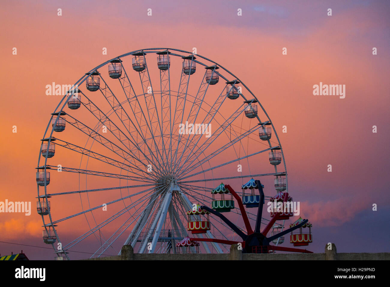 Southport, Merseyside UK Weather. 25 Septembre, 2016. Nuages glorieux derrière la petite et grande grande roue au coucher du soleil avant 4 jours de pluie. Prévisions pour le lundi est des foyers de la pluie, peut-être lourd pour un temps avec un renforcement de la brise. Credit : MediaWorldImages/Alamy Live News Banque D'Images
