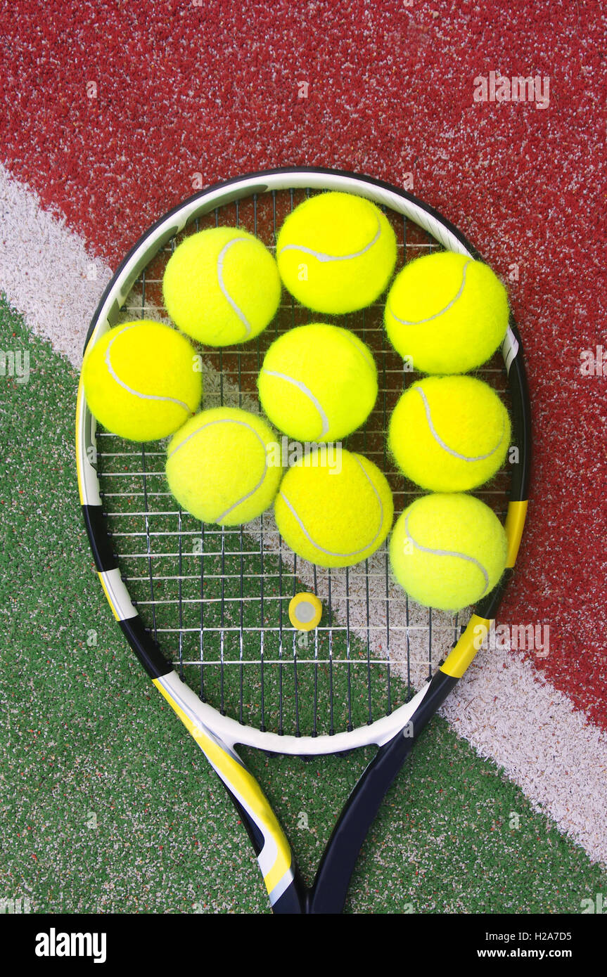 Raquette de tennis avec des balles sur cour Banque D'Images