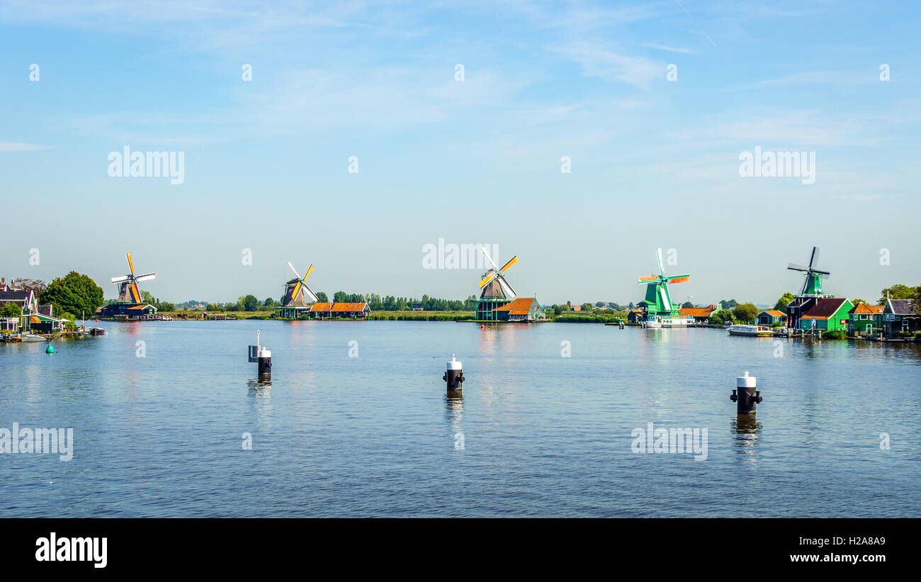 Vue depuis la rivière Zaan de vieux moulins à vent hollandais et les maisons historiques le long de la rivière, au village historique de Zaanse Schans aux Pays-Bas Banque D'Images