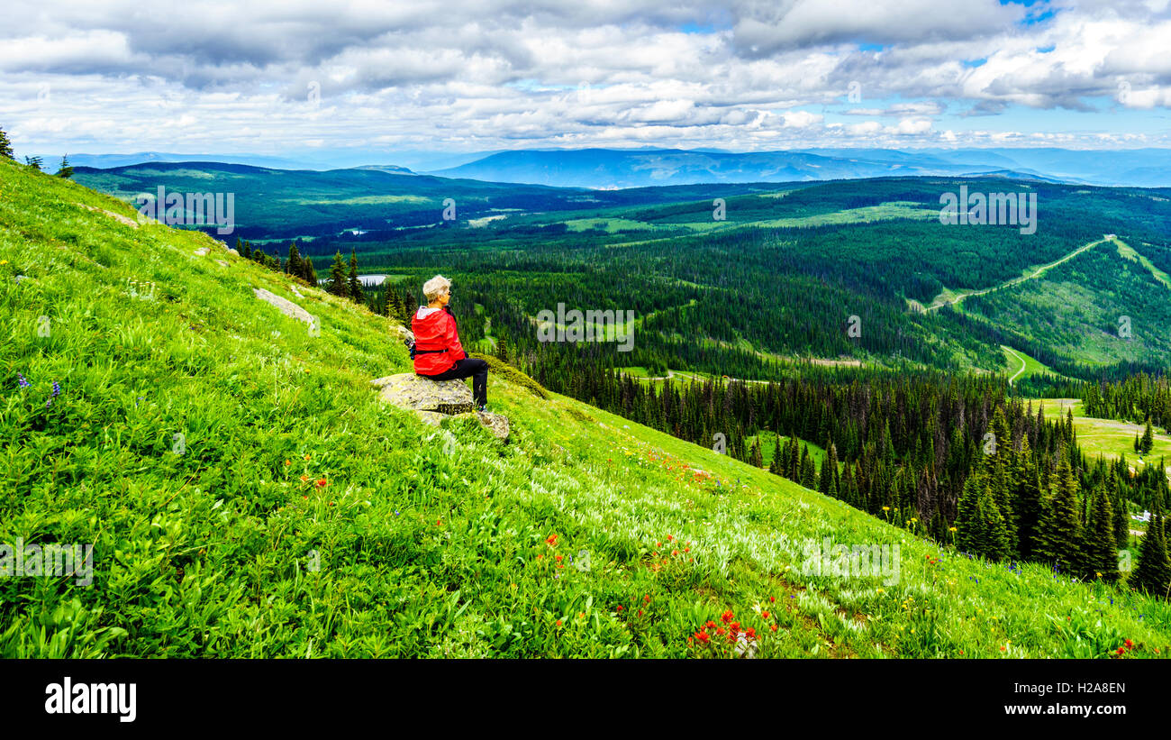 Senior woman bénéficiant d'une très belle vue du village de Sun Peaks pendant une randonnée de montagne Tod dans le Highlands of British Columbia Shuswap Banque D'Images