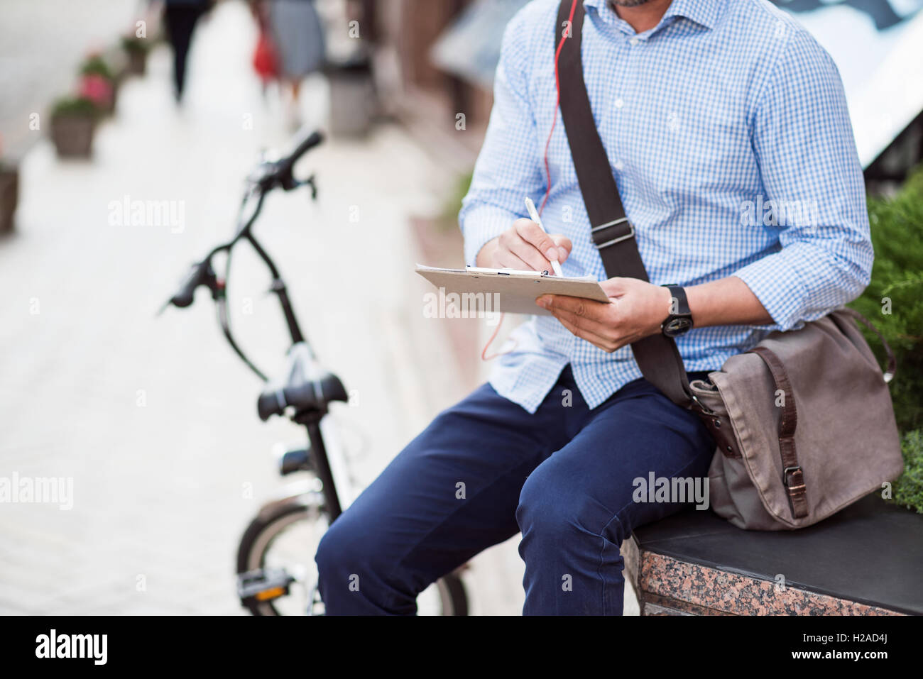 Homme agréable assis dans la rue Banque D'Images