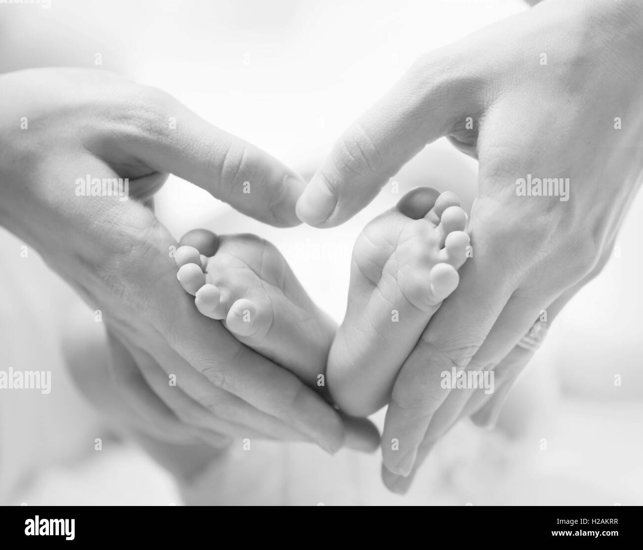 Petits pieds du nouveau-né sur les mains en forme de coeur libre Banque D'Images