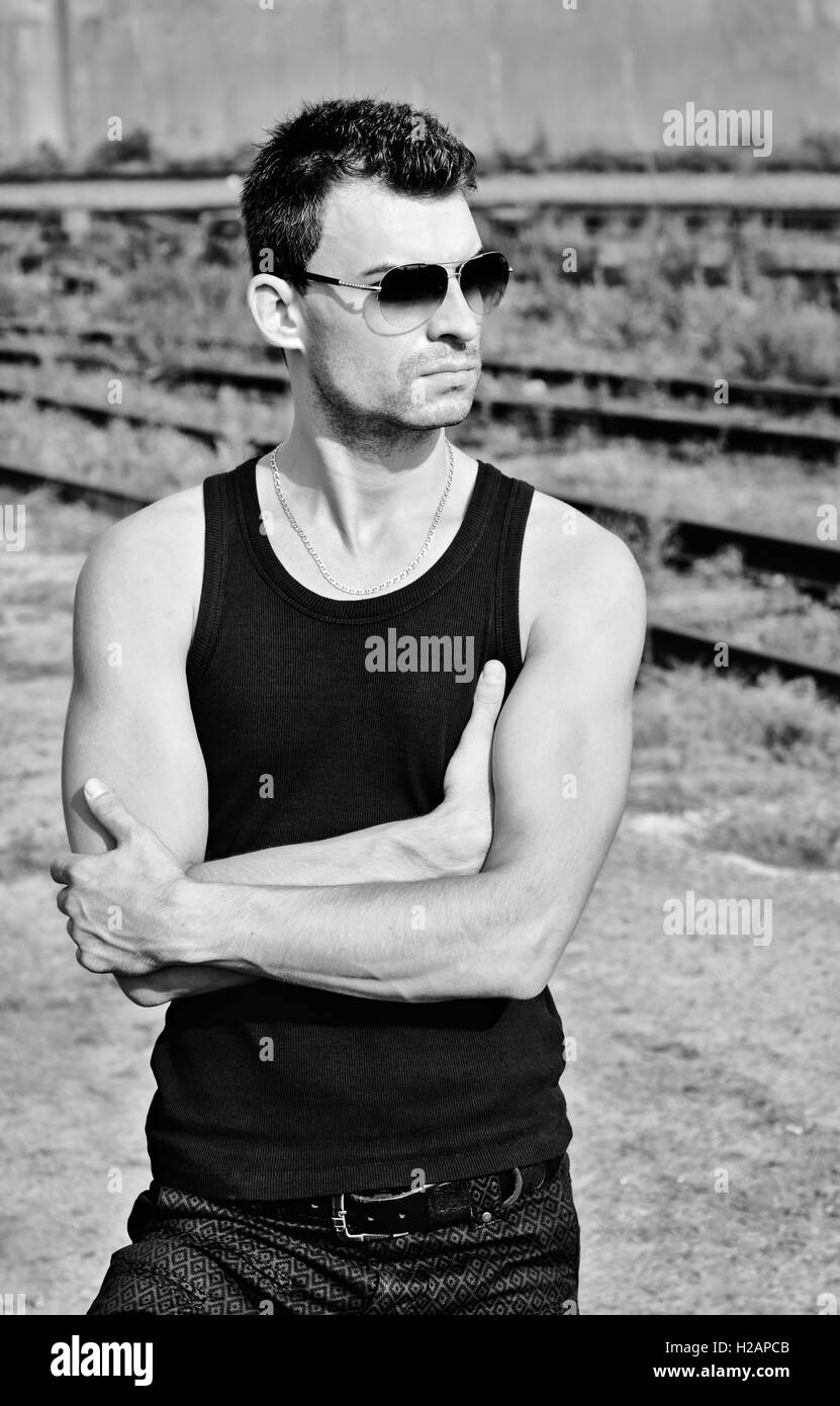 Fashion shot : portrait of handsome young man in black shirt portant des lunettes de soleil. Le noir et blanc Banque D'Images