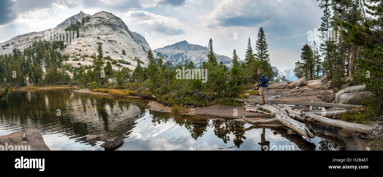 Randonneur sur un lac, montagnes reflétée dans un lac, le lac de la cathédrale, la Sierra Nevada, Yosemite National Park, plage de la Cathédrale Banque D'Images