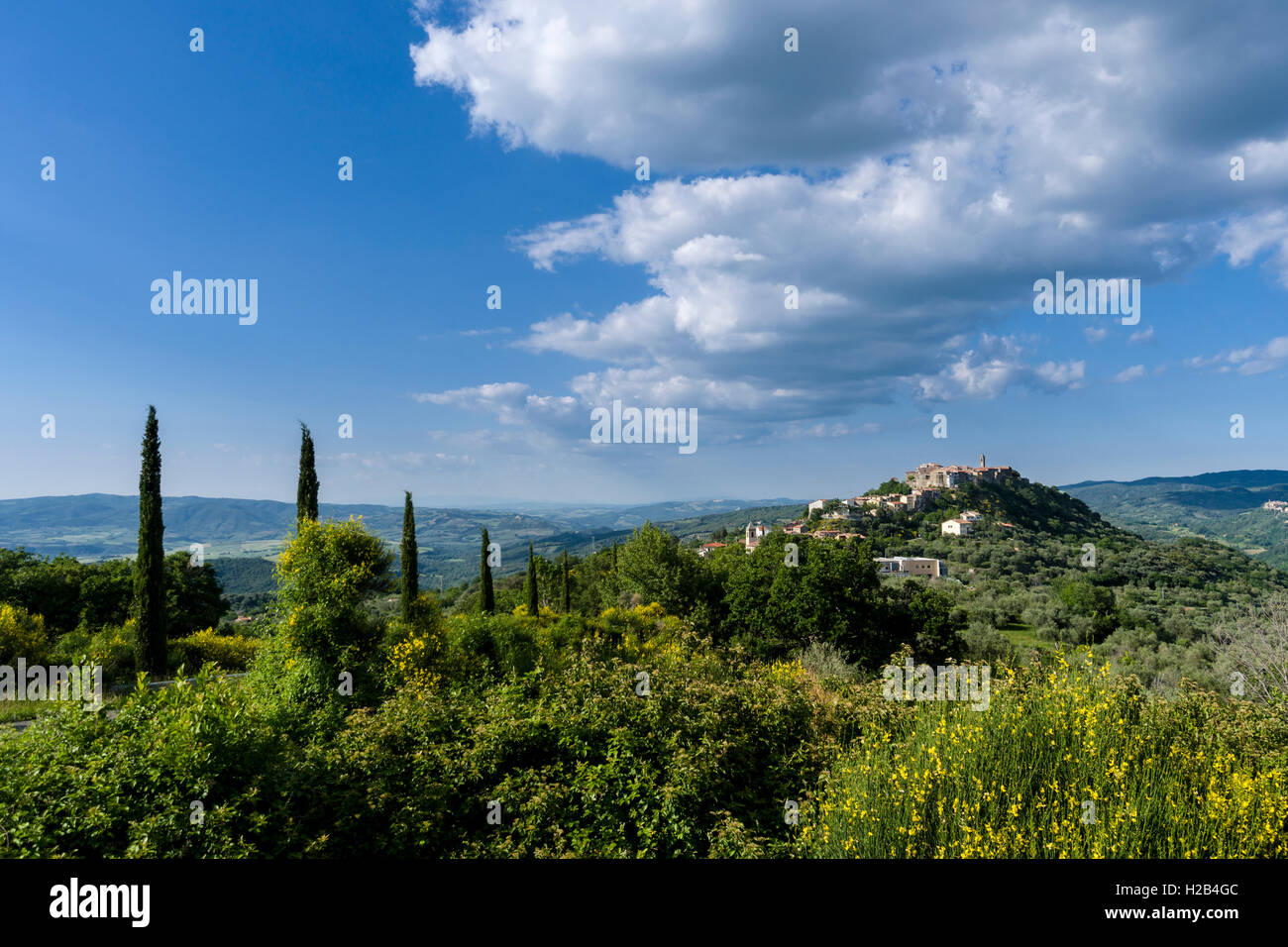 Paysage typique de la Toscane avec des collines et des cyprès, dans le dos une ville sur une colline, Montegiovi, Toscane, Italie Banque D'Images