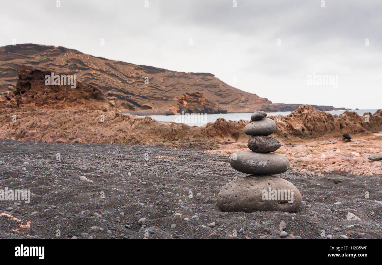 Des pierres empilées sur une plage à El Golfo dans un jour nuageux Banque D'Images