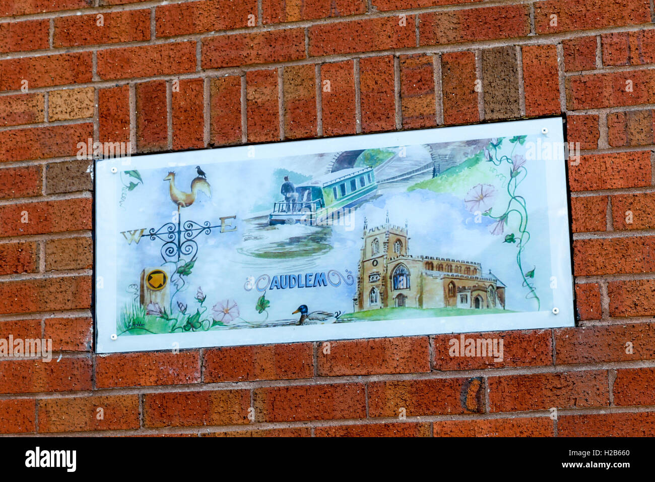 Une peinture sur une plaque sur un mur de brique rouge dans le village de Audlem Cheshire England UK Banque D'Images