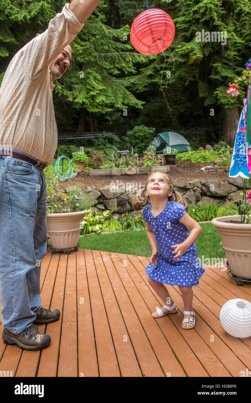 Trois ans, fille jouant avec une lanterne de papier avec son grand-père à Issaquah, Washington, USA Banque D'Images