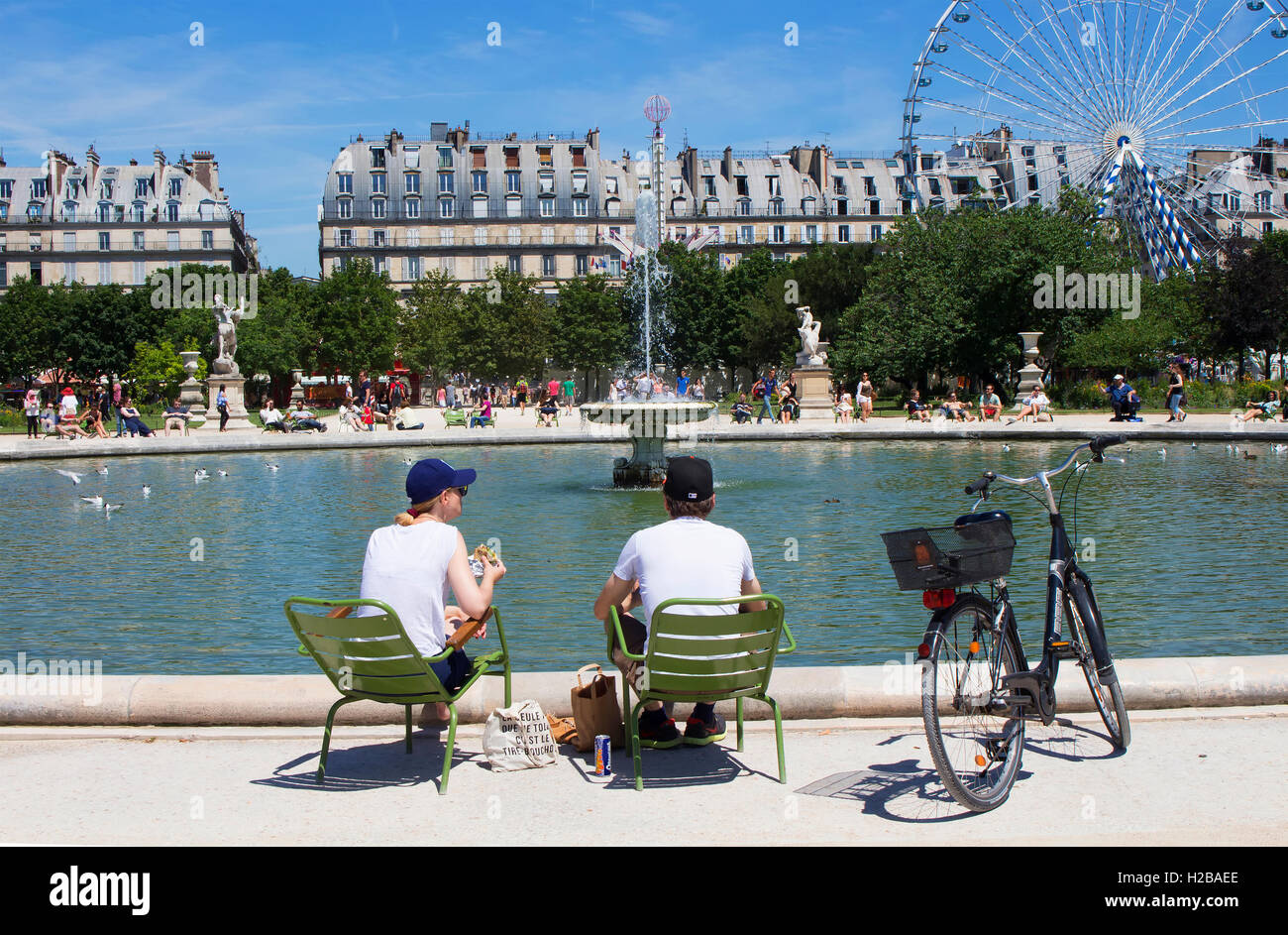 L'homme et la femme ont le déjeuner par piscine au Jardin des Luxembourg.  Un vélo, grande roue, fontaine et de bâtiments par le parc sont dans le v  Photo Stock - Alamy