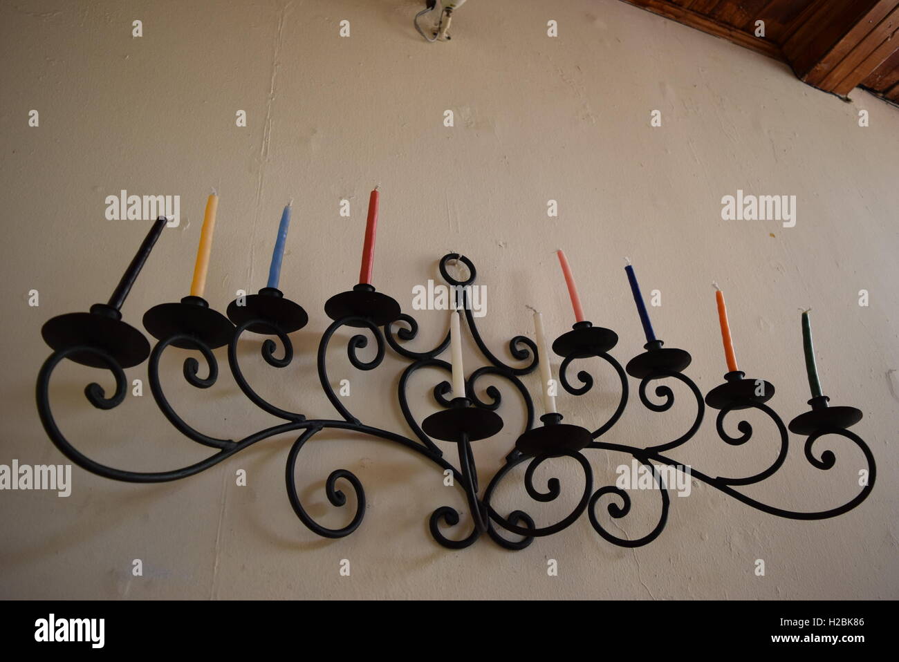 Lustre noir avec des bougies de différentes couleurs accroché au mur d'un hotel à Antigua, Guatemala Banque D'Images