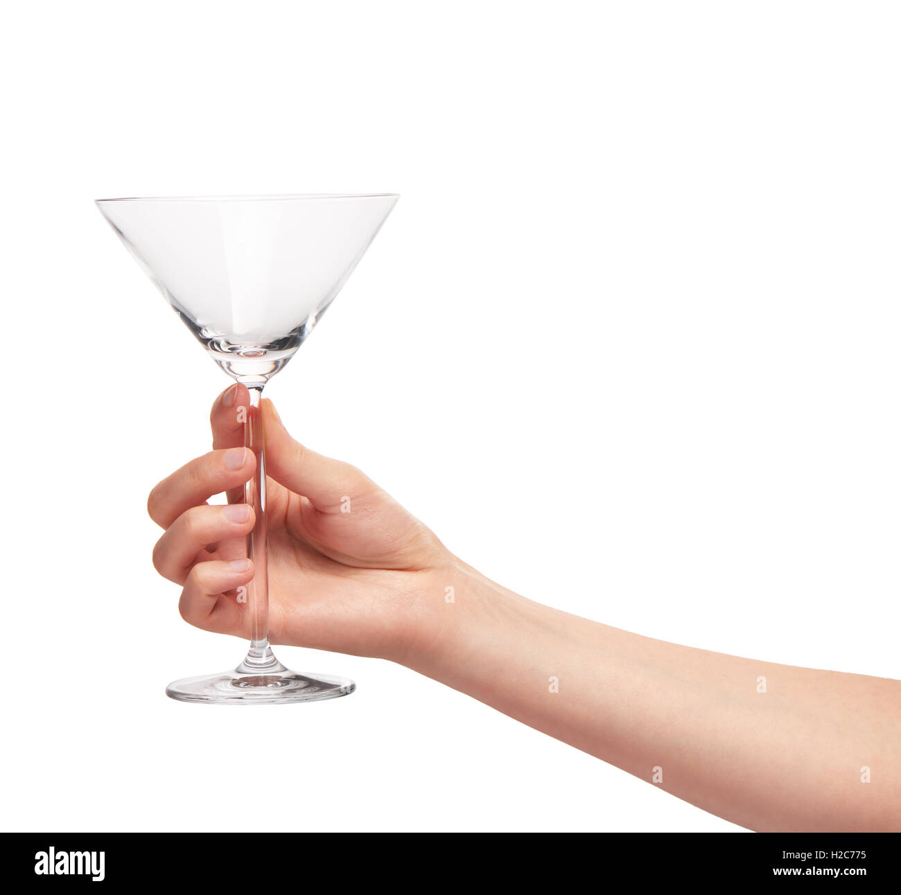 Close up of female hand holding transparent propre vide verre martini contre fond blanc. Chemin de détourage pour bordure en verre Banque D'Images