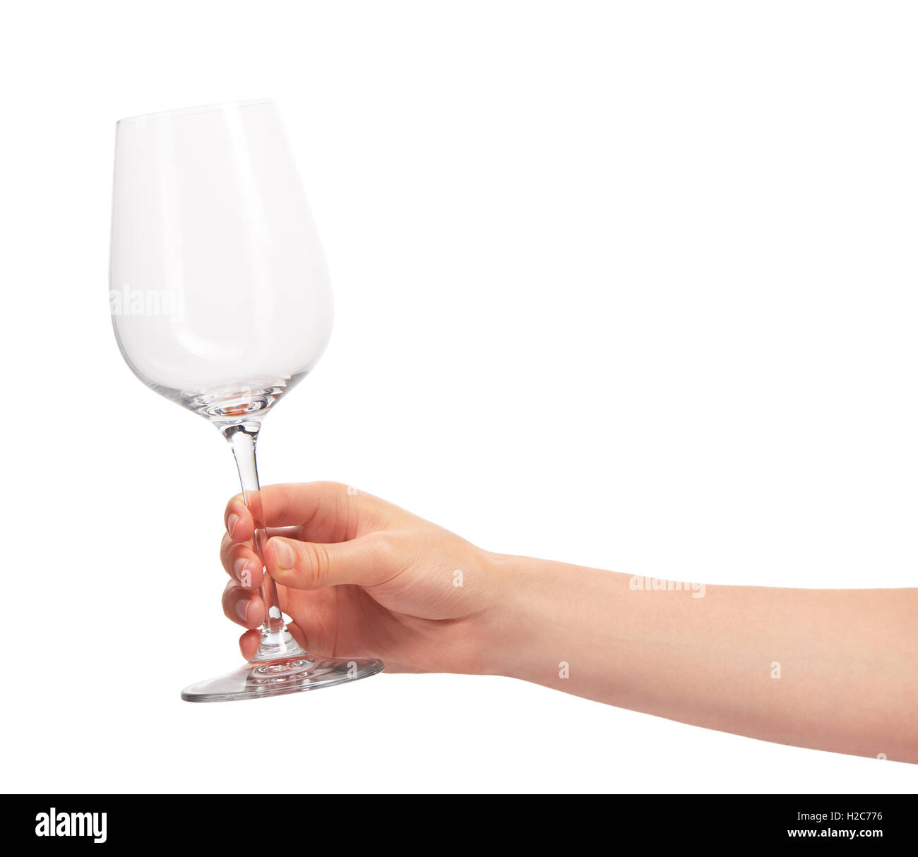 Close up of female hand holding transparent propre vide verre de vin contre l'arrière-plan blanc. Chemin de détourage pour bordure en verre Banque D'Images