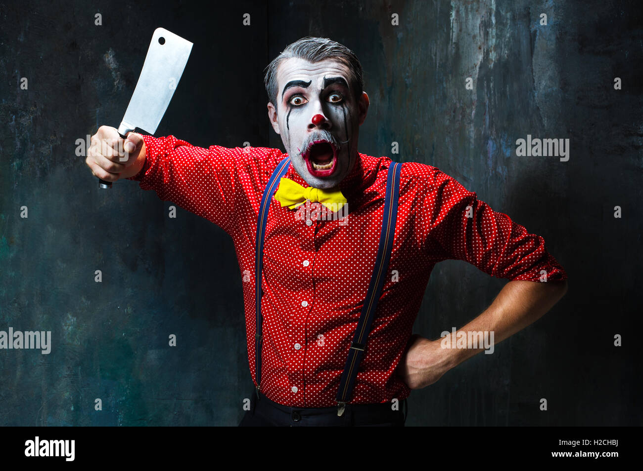 La scary clown tenant un couteau sur dack. Concept d'Halloween Banque D'Images