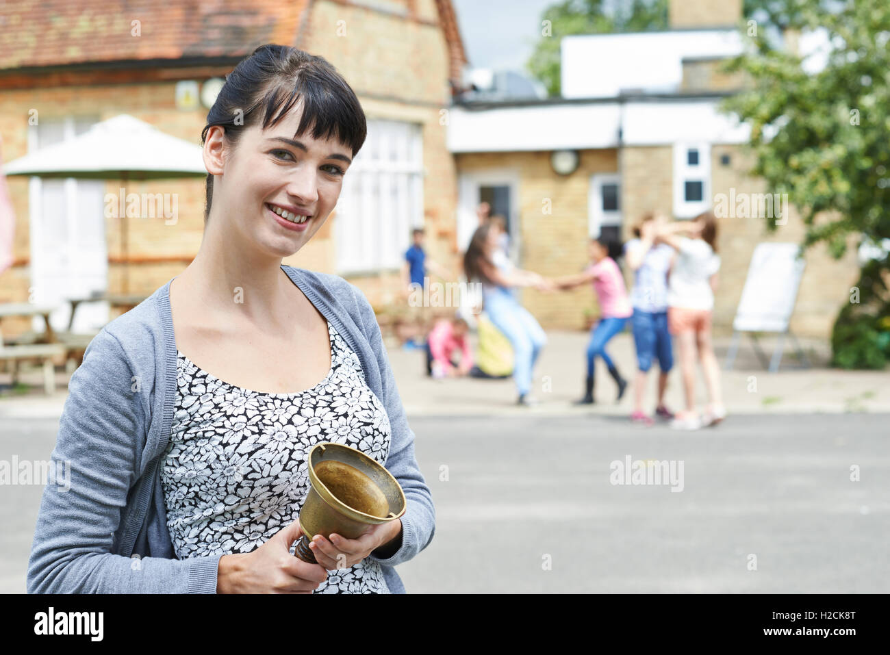 Portrait d'enseignant avec Bell la supervision à l'école Pause Jeux pour Enfants Banque D'Images