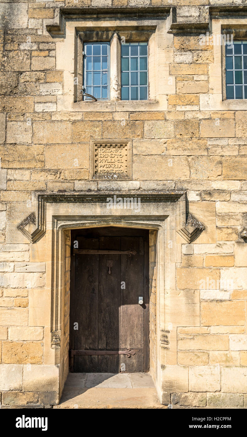 Porte de la vieille maison en pierre de Cotswold avec inscription latine gravée dans la pierre Banque D'Images