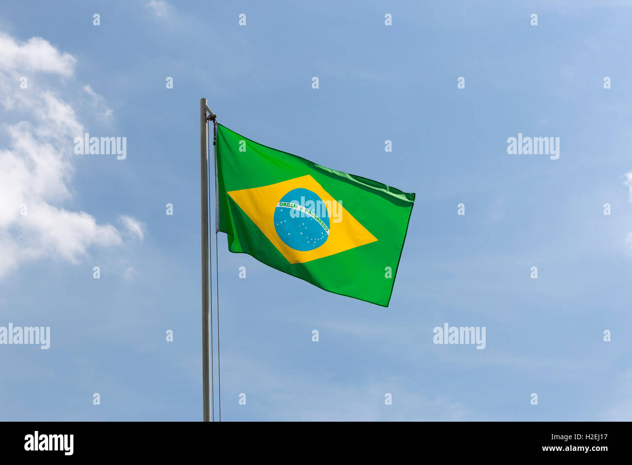 Drapeau national du Brésil sur un poteau en face de ciel bleu Banque D'Images