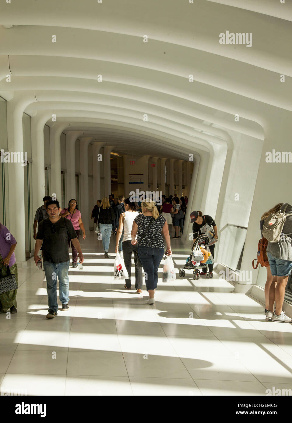 Les visiteurs et clients dans l'Oculus Mall au World Trade Centre à pied à travers l'un des couloirs donnant sur le hall central d'un côté et les magasins de l'autre. La ville de New York. Banque D'Images