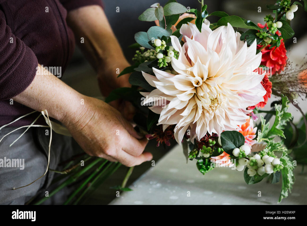 Des arrangements de fleurs biologiques. Une femme de la création d'un bouquet attachés à la main. Banque D'Images