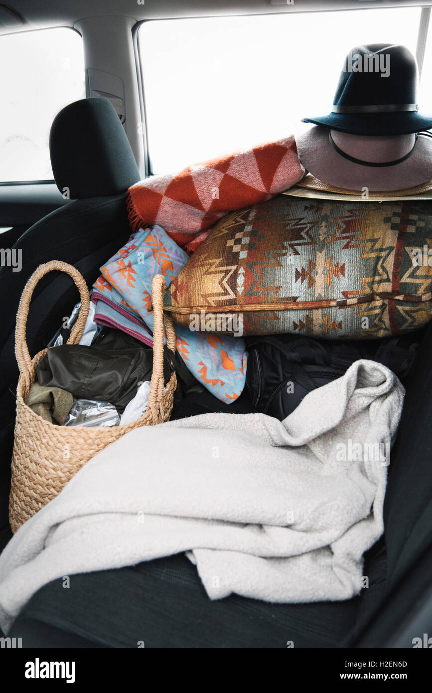 Close up d'éléments sur le siège arrière d'une voiture, un coussin, un chapeau et un sac et couverture. Banque D'Images