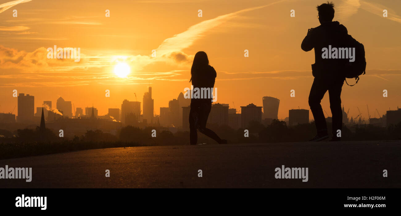 Primrose Hill, Londres, le 28 octobre 2016. Météo France : les marcheurs sur Primrose Hill sont silhouette sur le gratte-ciel de la ville comme l'aube sur Londres. Crédit : Paul Davey/Alamy Live News Banque D'Images