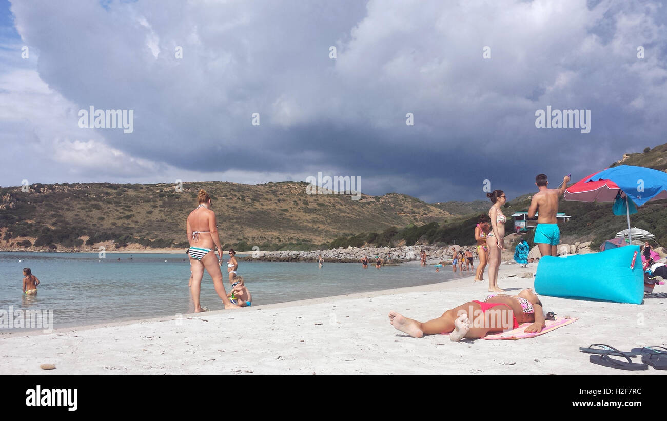 Plage de Punta Molentis, Perugia - 26 Septmber 2016 : uninidentify les gens sur la plage alors qu'un nuage noir est entrée dans Banque D'Images