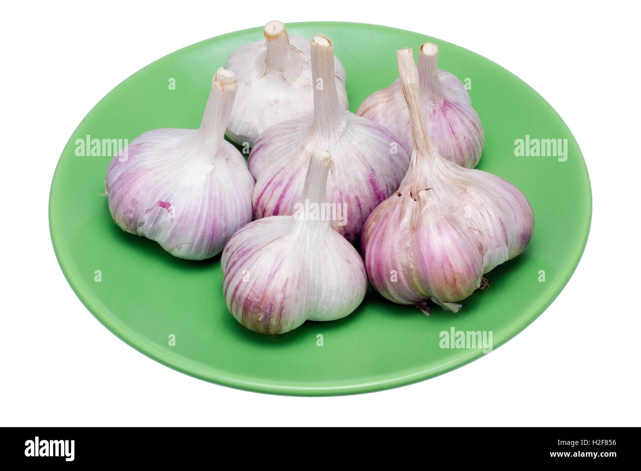 L'ail ukrainien caustique se trouve sur une plaque en céramique verte. Isolated on white Banque D'Images