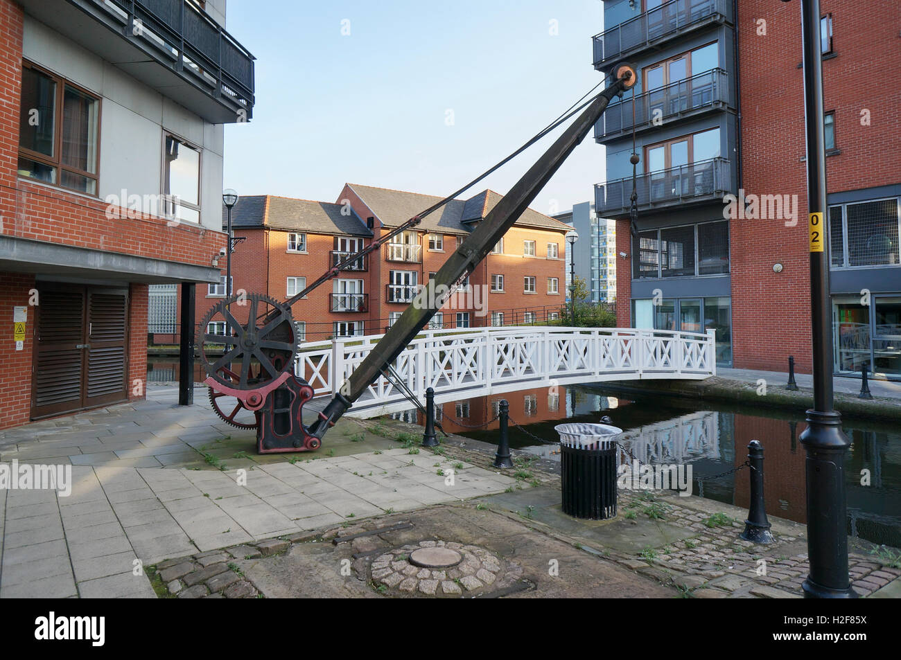 MANCHESTER, ANGLETERRE - 30 août 2016 : Le manuel de fer sur un treuil de chargement de l'eau des canaux de la ville. Maisons modernes en briques rouges près de t Banque D'Images
