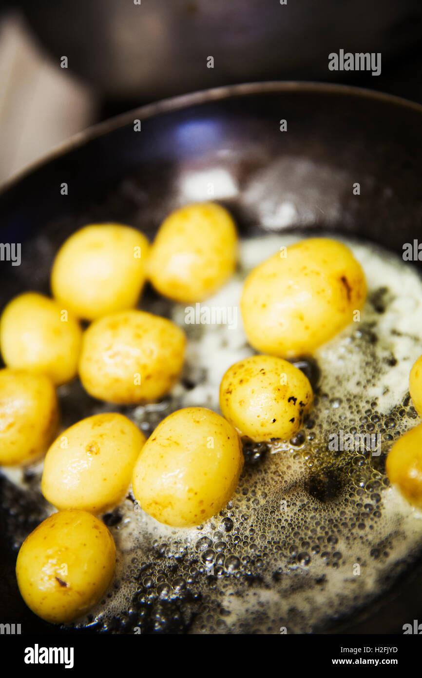 Sauteing pommes de terre dans une poêle, dans le beurre moussant. Banque D'Images