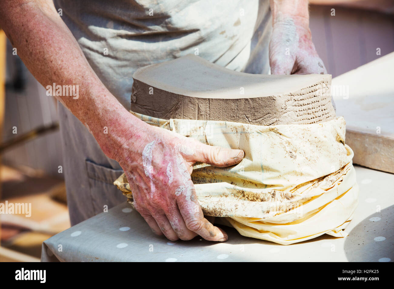 Une femme potter déballer un sac d'argile préparé pour des pots dans son atelier. Banque D'Images