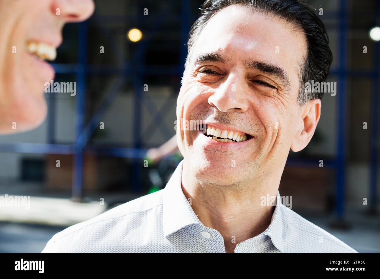 Deux personnes, hommes de parler ensemble à l'extérieur, de prendre une pause-café. Banque D'Images
