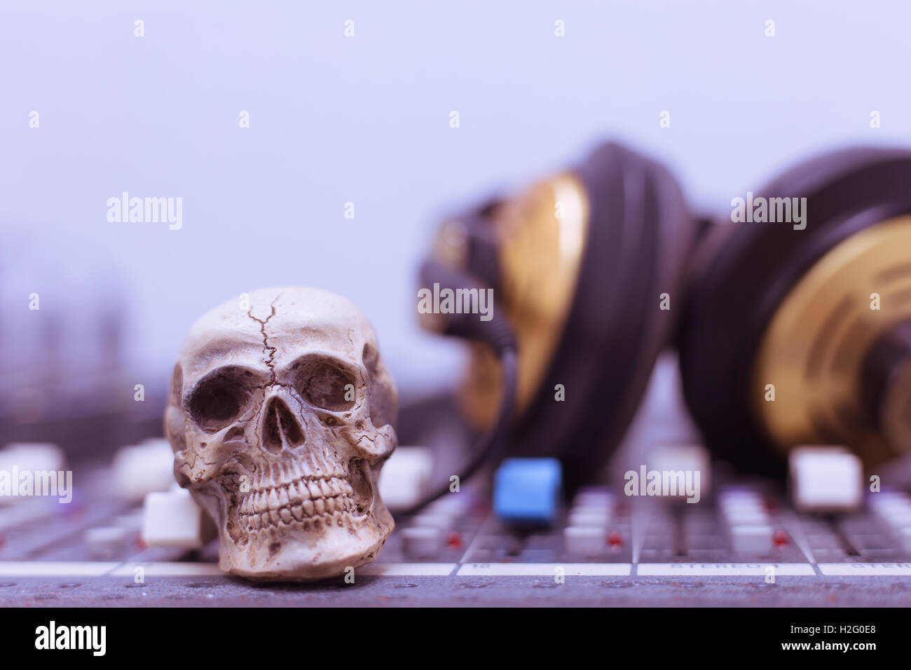 Crâne humain posé sur une table de mixage. Arrière-plan sur la console de mixage et de casques, Vintage Tone Banque D'Images