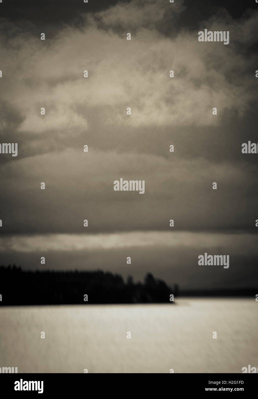 Paysage sombre floue avec lac et silhouette de forêt. Moody et sinistre scène nature, la Suède. Banque D'Images