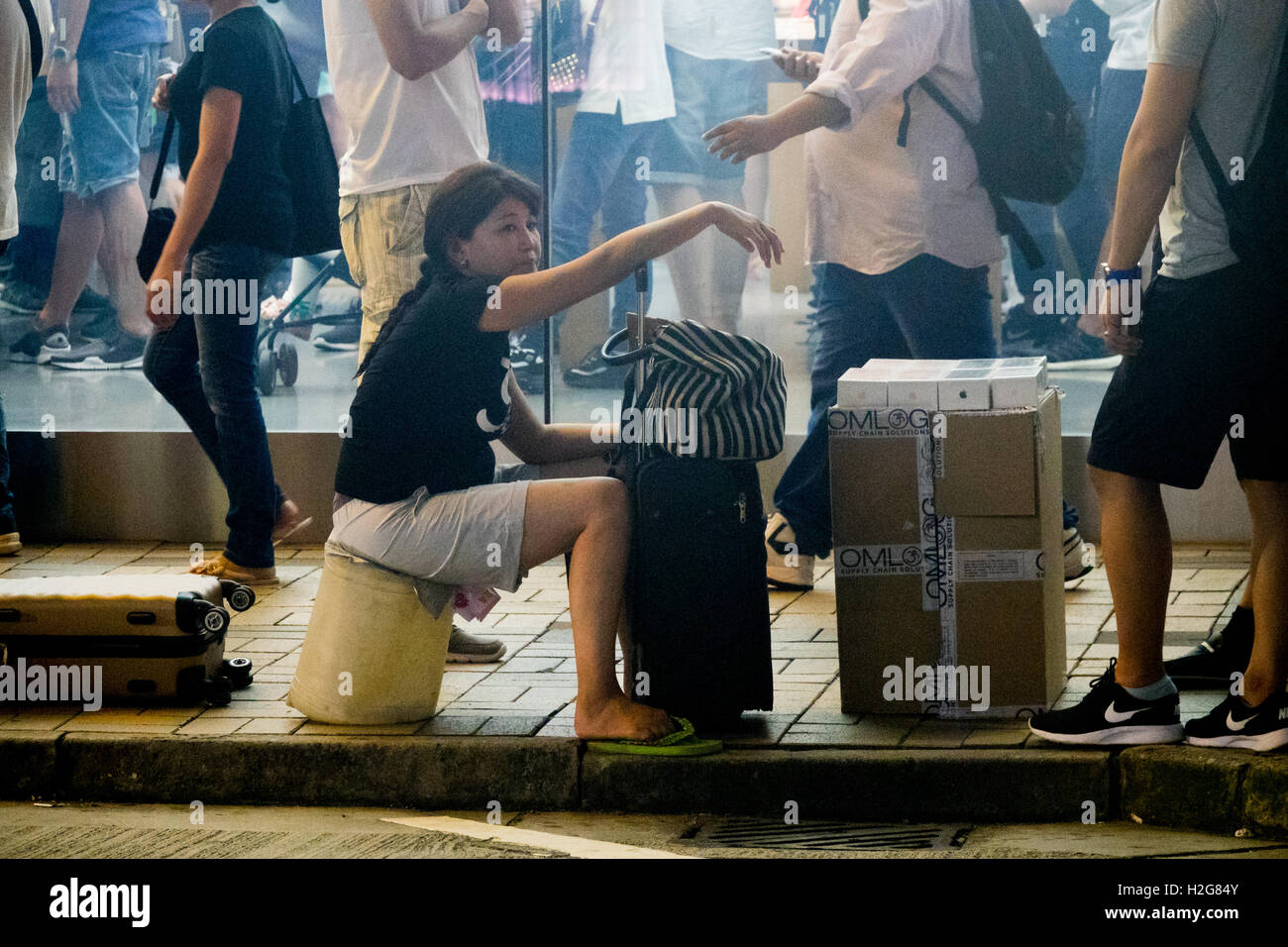 Une femme avec un fort de nouvel iPhone 7s à l'extérieur de l'Apple Store sur Canton Road à Hong Kong pour ceux qui vont payer pour éviter l'attente Banque D'Images